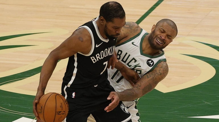 Kevin Durant of the Brooklyn Nets is defended by P.J. Tucker of...