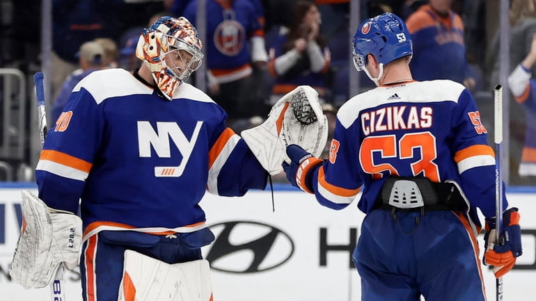 Semyon Varlamov and Casey Cizikas of the Islanders celebrate after defeating the Predators...