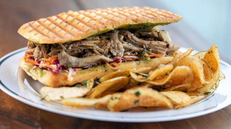 The hot porchetta panino with house-made Tuscan potato chips at...