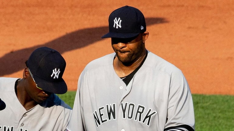 Yankees starting pitcher CC Sabathia hands over the ball to...