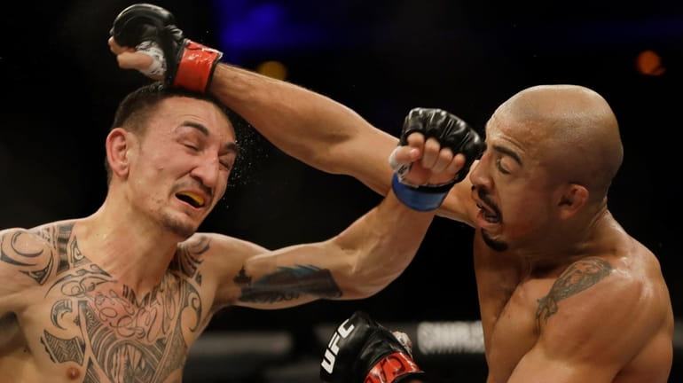 Jose Aldo, of Brazil, right, trades punches with Max Holloway,...