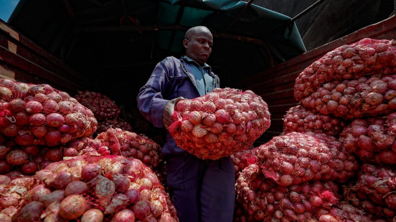 Timothy Kinyua unloads sacks of onions from Ethiopia at an...
