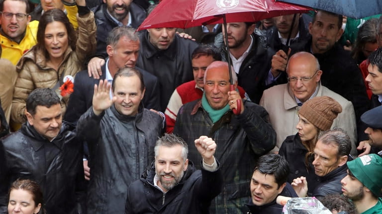 Portuguese caretaker Prime Minister Antonio Costa holds an umbrella with...