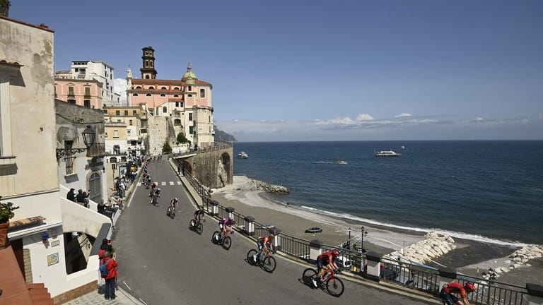 Cyclists ride along the coastline during the sixth stage of...