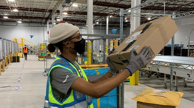 Crystal A. Anthony sorts packages at Amazon's last-mile warehouse in Shirley....