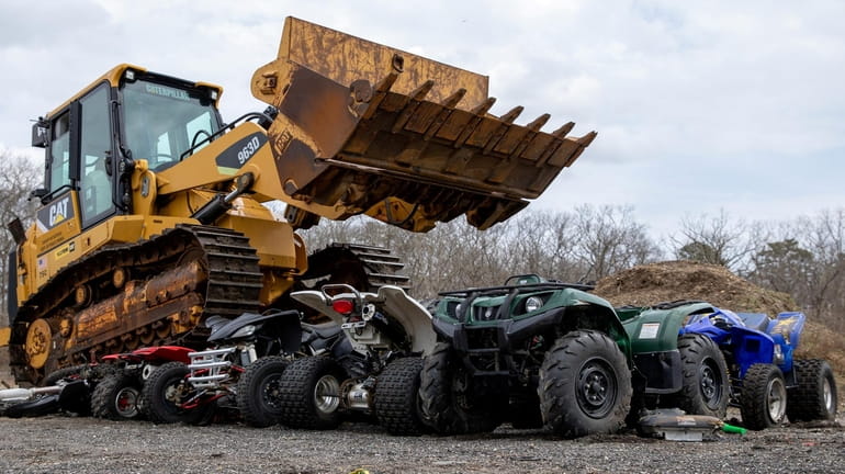 Confiscated ATVs are crushed by a bulldozer at the Suffolk...