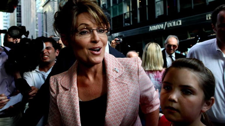 Former Alaska Gov. Sarah Palin walks to the door of...