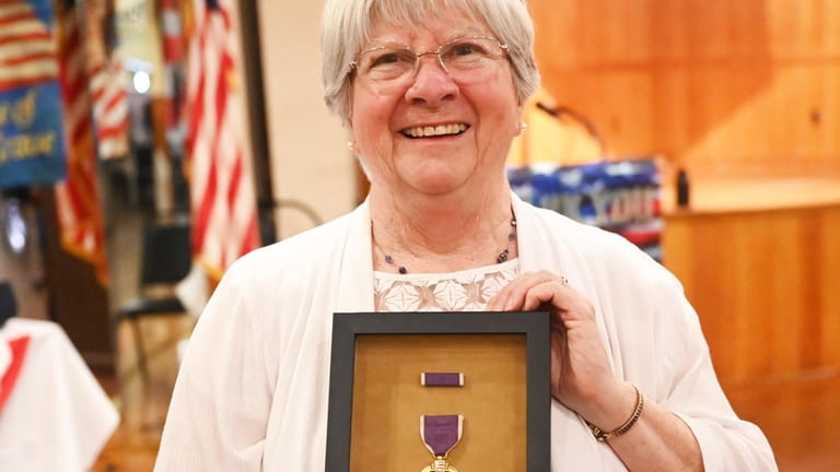 Lynn Holloman Bryson, holds the Purple Heart that her late...