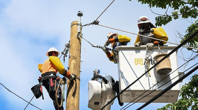 Workers contracted by PSEG  work on restoring power to homes...