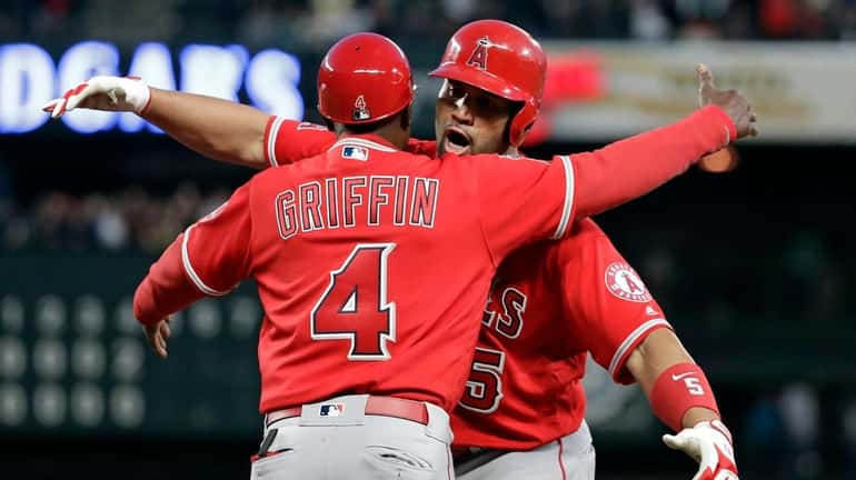 The Angels' Albert Pujols, right, embraces first base coach Alfredo...
