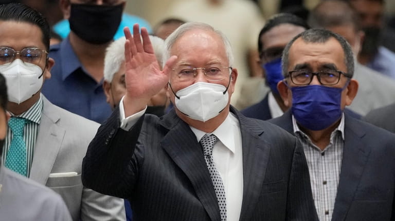 Former Malaysian Prime Minister Najib Razak, center, wearing a face...