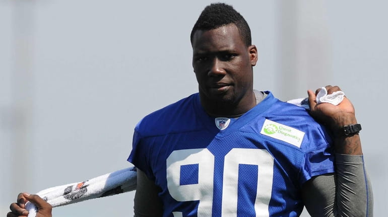 Giants defensive end Jason Pierre-Paul uses a towel to stretch...