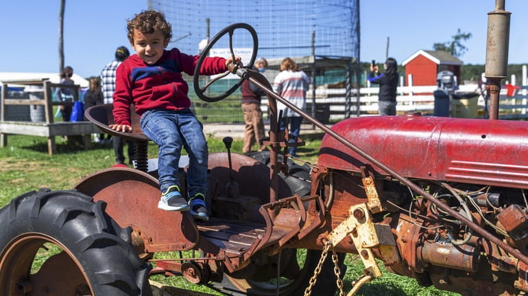 Jason Bourboulis, 3, from Laurel sits on the stationary tractor...