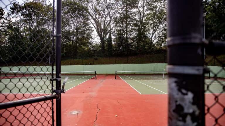 Cracks seen Thursday on a tennis court surface in Heckscher...