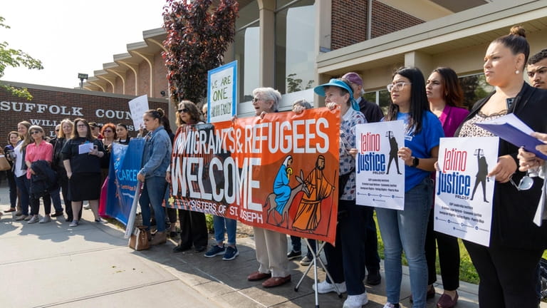 Immigrant advocates rally outside the Suffolk County legislature in Hauppauge...