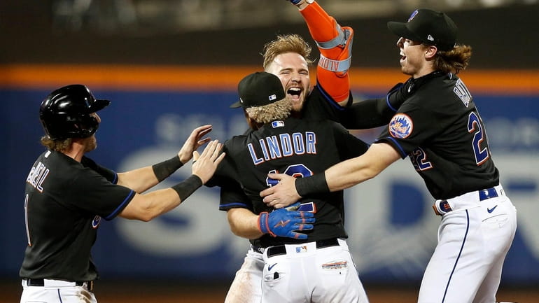 Pete Alonso of the Mets celebrates his walk-off base hit against the...