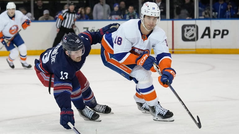 The Rangers' Alexis Lafreniere chases the Islanders' Pierre Engvall on...