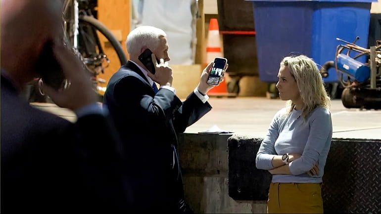Then-Vice President Mike Pence looks at a tweet by then-President...