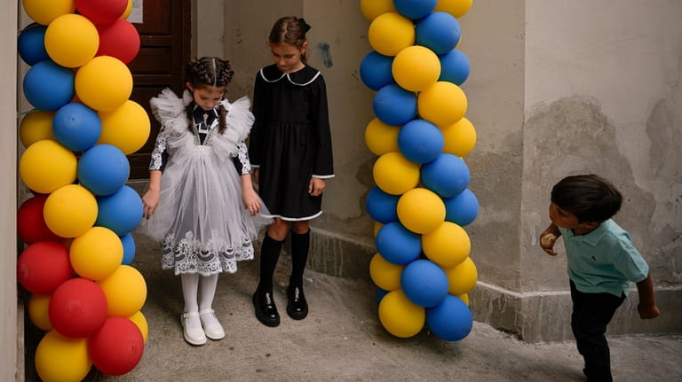 FILE.- A boy watches Ukrainian refugee girls posing for pictures...