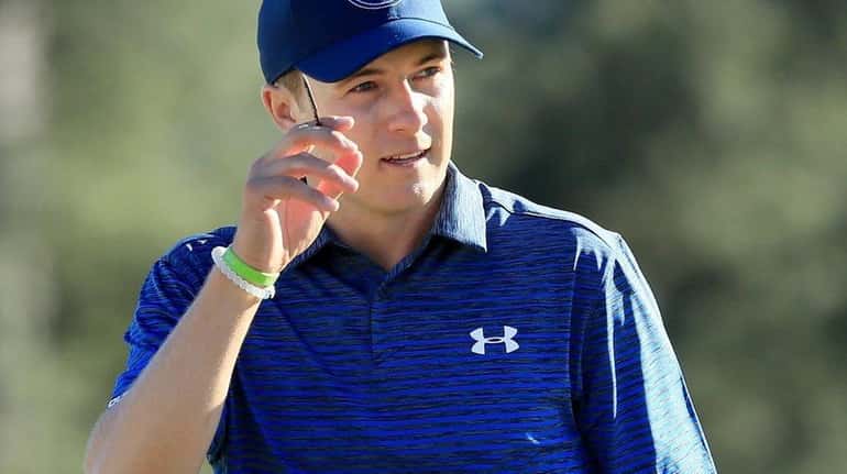 Jordan Spieth waves on the 18th green during the third...