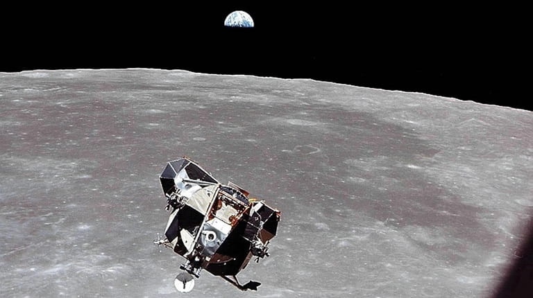 The lunar module approaches for docking with the earthrise in...