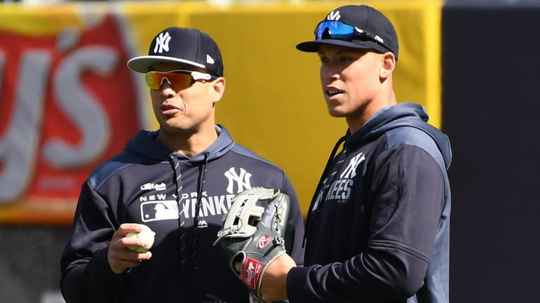 The Yankees' Giancarlo Stanton, left, and Aaron Judge look on...
