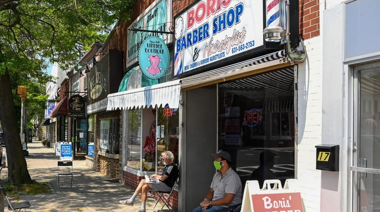 Customers wait for a haircut at Boris' Barbershop on Main...