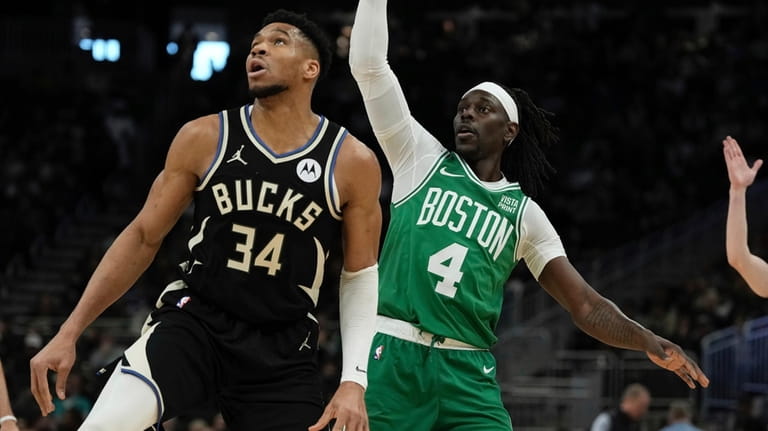 Boston Celtics' Jrue Holiday watches his shot with Milwaukee Bucks'...