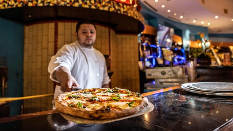 Olivos' Dennis Mejia with a wood-fired Margherita pizza at Roosevelt Field's...