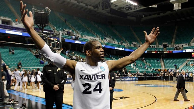 Tu Holloway of the Xavier Musketeers celebrate the 70-58 victory...