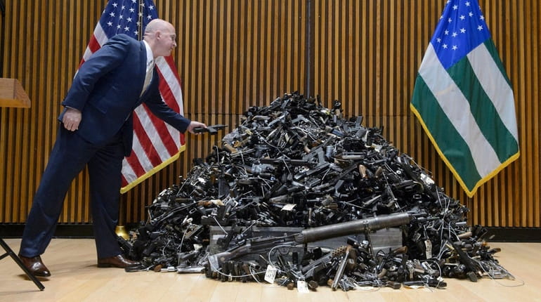 NYPD Commissioner James P. O'Neill tosses a pistol on top...