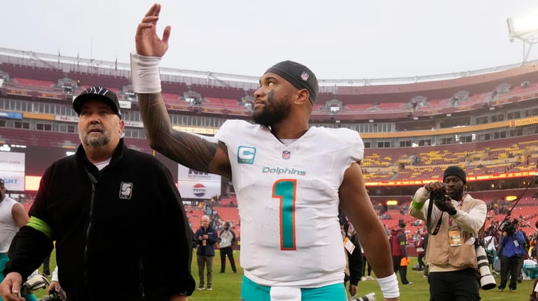 Miami Dolphins quarterback Tua Tagovailoa (1) gestures while walking off...