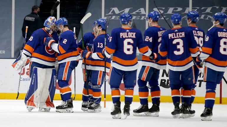 Islanders goalie Ilya Sorokin celebrates with teammates after defeating the Devils at...