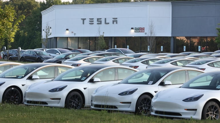 New Tesla electric vehicles fill the car lot at the...