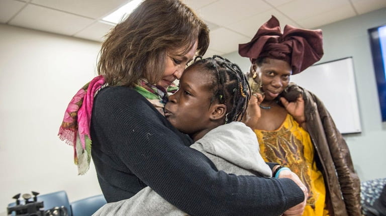 Janet Silva, 12, hugs Donna Jungereis, chair of the Global...