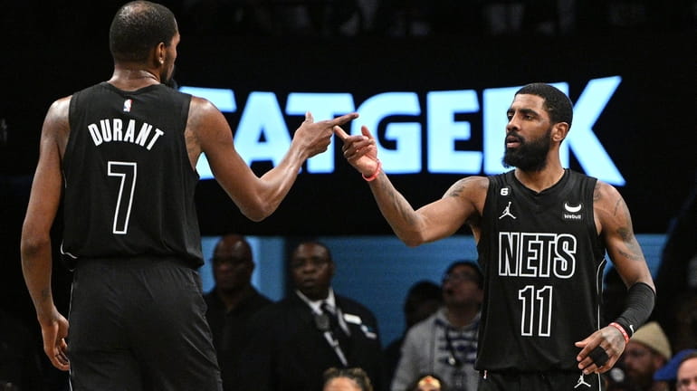 Nets forward Kevin Durant and guard Kyrie Irving gesture in...