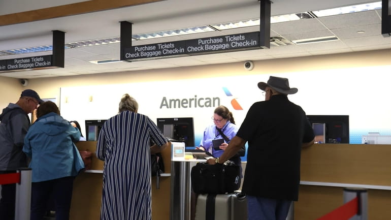 Passengers check-in for their flight for American Airlines from Long...