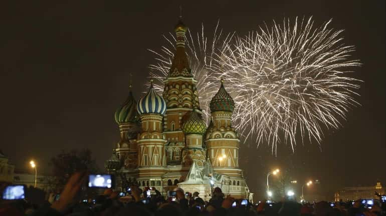 Fireworks explode over St. Basil's Cathedral as people celebrate the...
