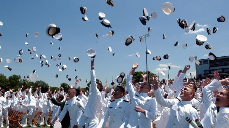 Graduates of the U.S. Merchant Marine Academy toss caps at...