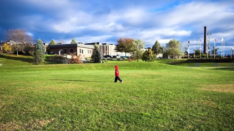 A child walks through a park in a city.