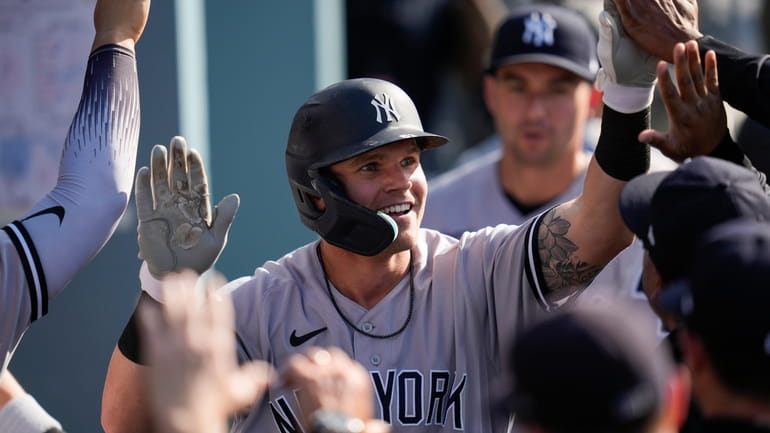 Yankees' Jake Bauers, center, celebrates in the dugout after hitting...