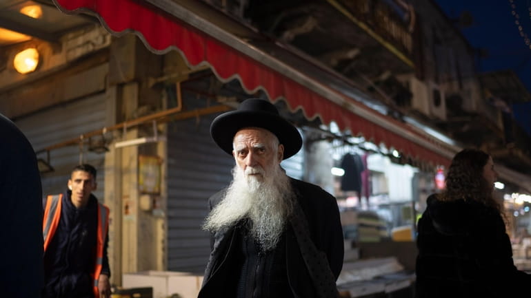 An elderly ultra-Orthodox Jewish man looks on as he walks...