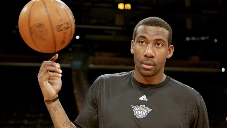 Phoenix Suns forward Amare Stoudemire spins a ball on his...