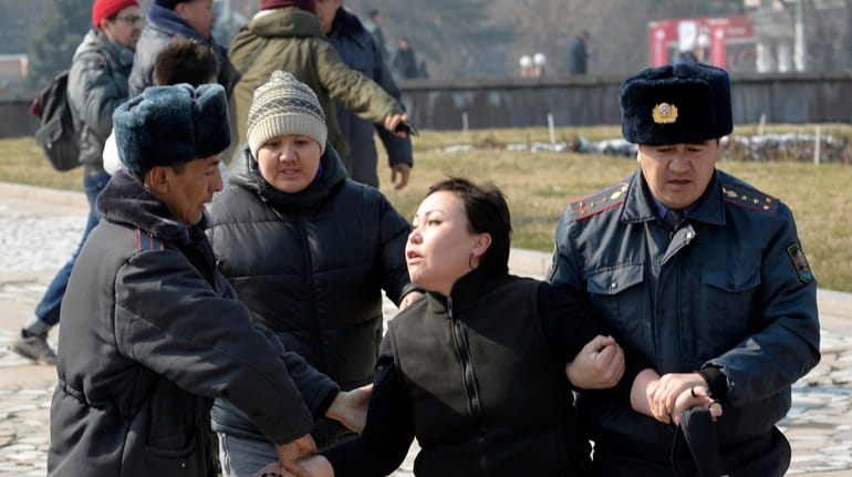 Kyrgyz policemen detain an activist of the Femen women's rights...