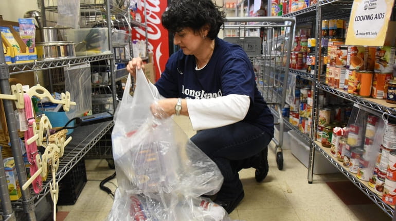 Volunteer Marilu Basile of Setauket weighs donations for government workers Thursday...