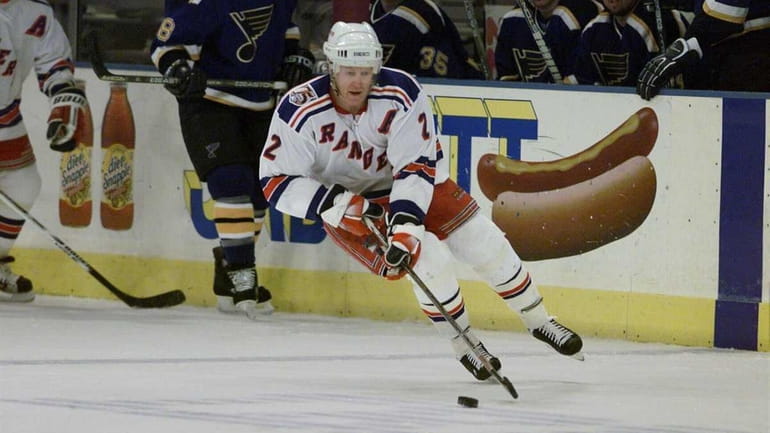 New York Rangers' Brian Leetch pushing the puck up the...