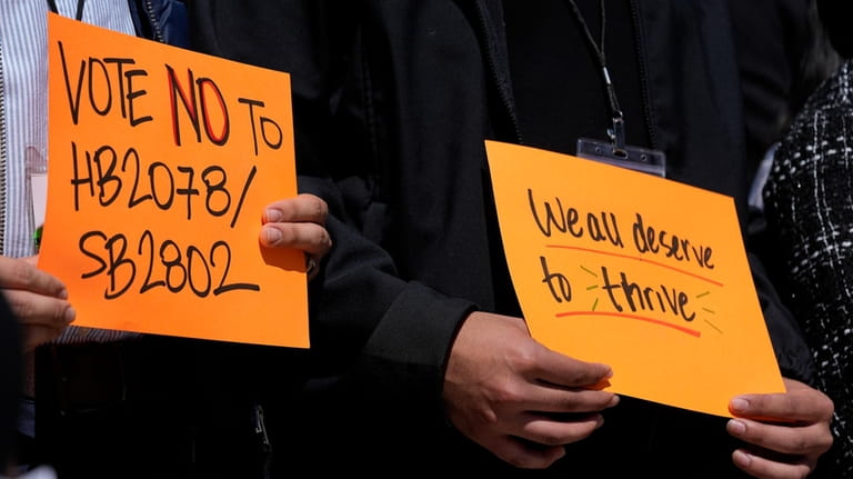 People hold signs during a news conference of the Tennessee...
