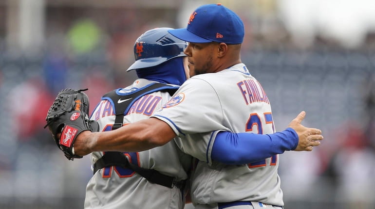 Mets relief pitcher Jeurys Familia and catcher Travis d'Arnaud embrace...