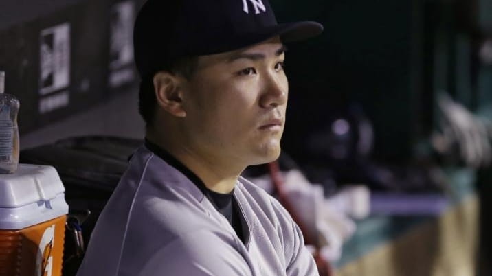 Yankees starting pitcher Masahiro Tanaka watches from the dugout after...