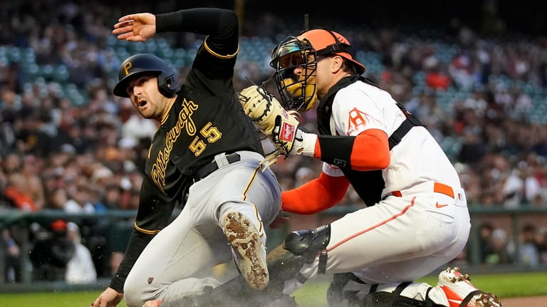San Francisco Giants catcher Patrick Bailey, right, tags out Pittsburgh...